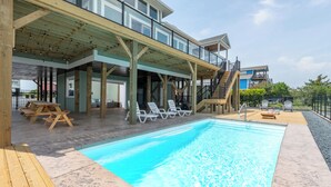 A pool area with lounge chairs and a wooden deck.