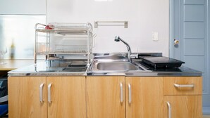 A modern kitchen with stainless steel appliances, a double sink, and wooden cabinets. - Ganghwa Haemolupension (Incheon)