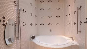 A modern bathroom with a freestanding bathtub, a handheld showerhead, and a wall-mounted toilet.