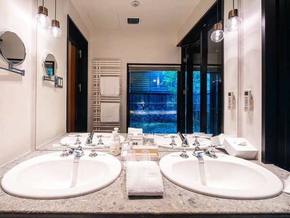 A bathroom with two sinks, a mirror, and a view of a blue outdoor area.