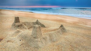 A beach with sand mounds and a pier in the background. - Sandy Paws Townhouse, Private Mini Water Park, Dog Friendly! (Kill Devil Hills)