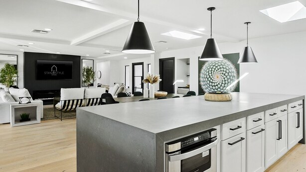 A modern kitchen with a large island, built-in oven, and white cabinetry. - SWSS 7BR Estate | Golf Sim | Sauna | Pool | Hot Tub | Putting Green | Volleyball | Games (Scottsdale)