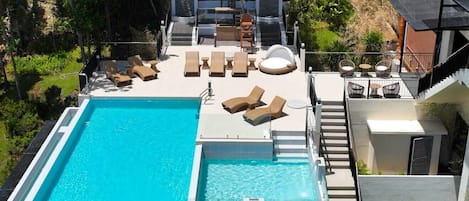 Utomhuspool, parasoller och livvakter på plats
