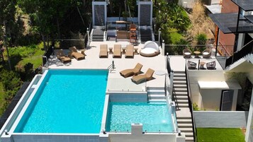 Una piscina al aire libre, sombrillas, socorrista en las instalaciones