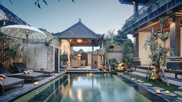 A serene pool area with lounge chairs, a gazebo, and lush greenery. - Sitala Suite (Ubud)