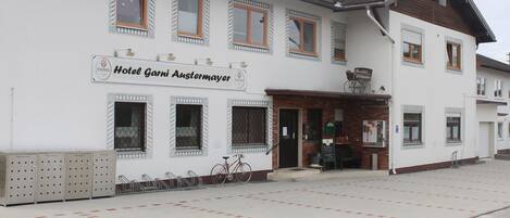 Un edificio blanco con un letrero que dice 'Hotel Garni Austermayer'.
