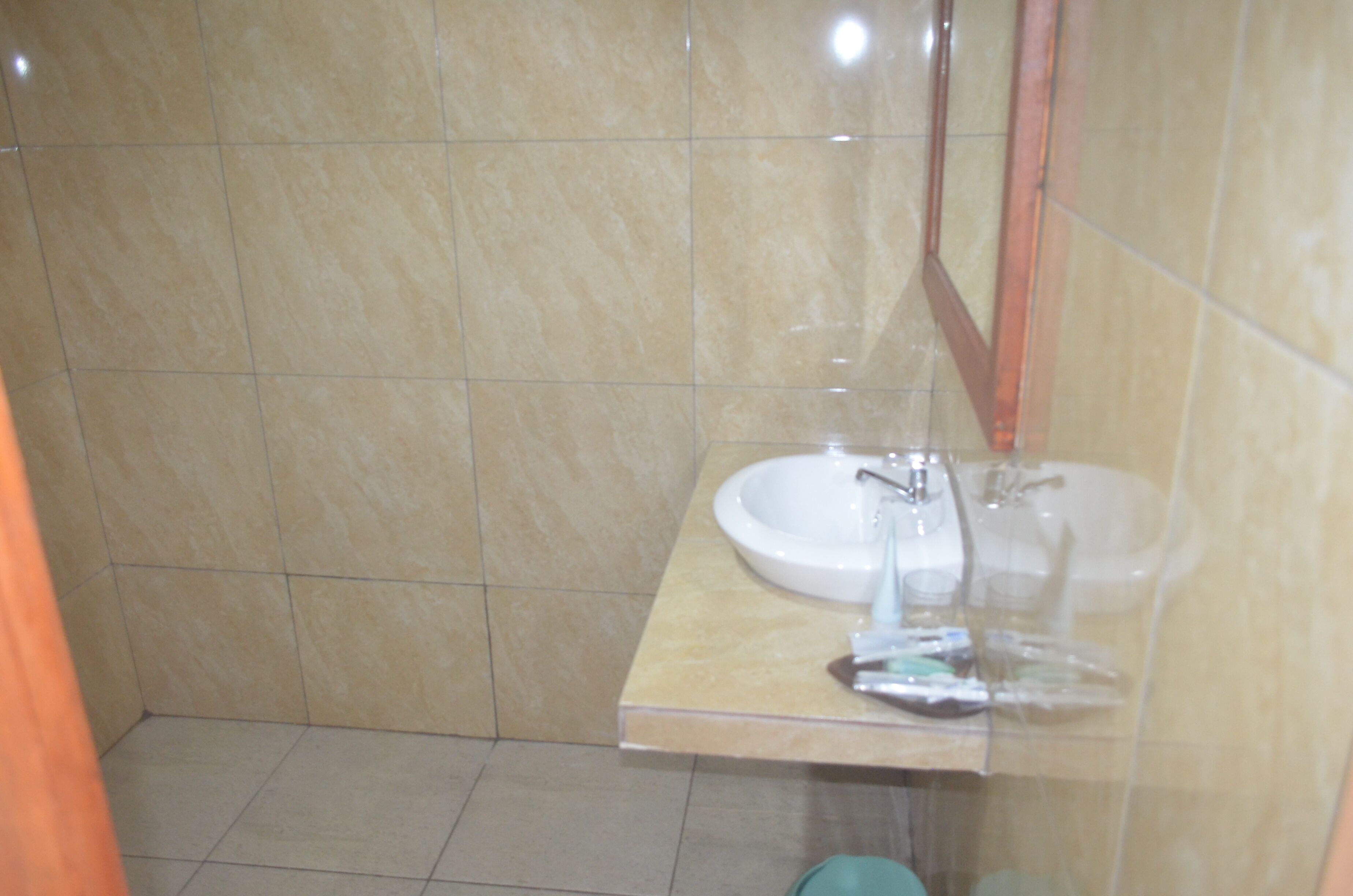 A bathroom with a sink, mirror, and tiled walls.