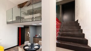 Een modern interieur met een eethoek, een trap en een glazen balustrade.