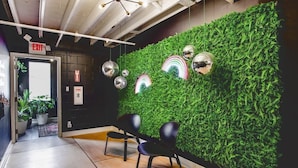 A modern interior with a green wall, black chairs, and a ceiling with exposed beams and lights. - Stellar Suites (Louisville)