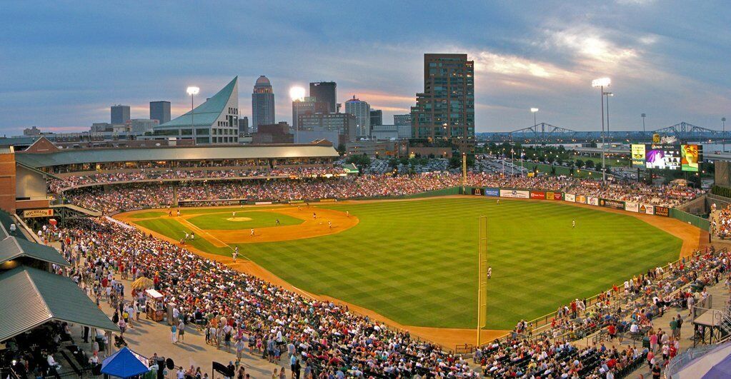 A large stadium with a baseball field, surrounded by a crowd of spectators.