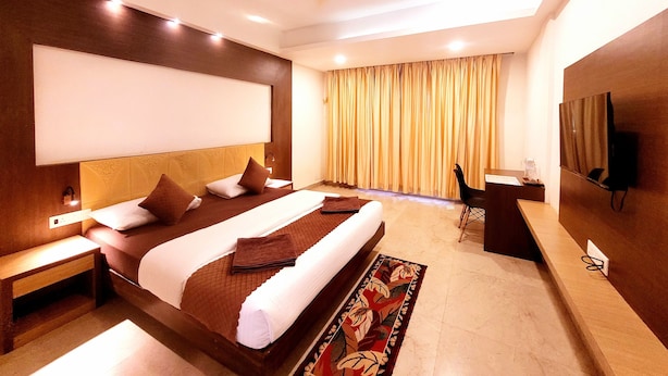 A modern hotel room with a large bed, a desk, and a television. - Famafa Beach Resort (Arambol)