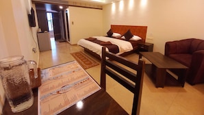A hotel room with a bed, a desk, a chair, a television, and a refrigerator. - Famafa Beach Resort (Arambol)