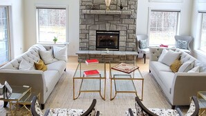 A spacious living room with a stone fireplace, two sofas, and a coffee table. - Hilltop Mansion Near Saratoga @ Rebecca's Fountain with Chef, Masseur & Fun (Niskayuna)