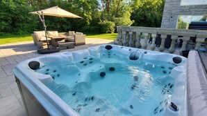 A hot tub with jets, a patio with outdoor furniture, and a stone balustrade. - Hilltop Mansion Near Saratoga @ Rebecca's Fountain with Chef, Masseur & Fun (Niskayuna)