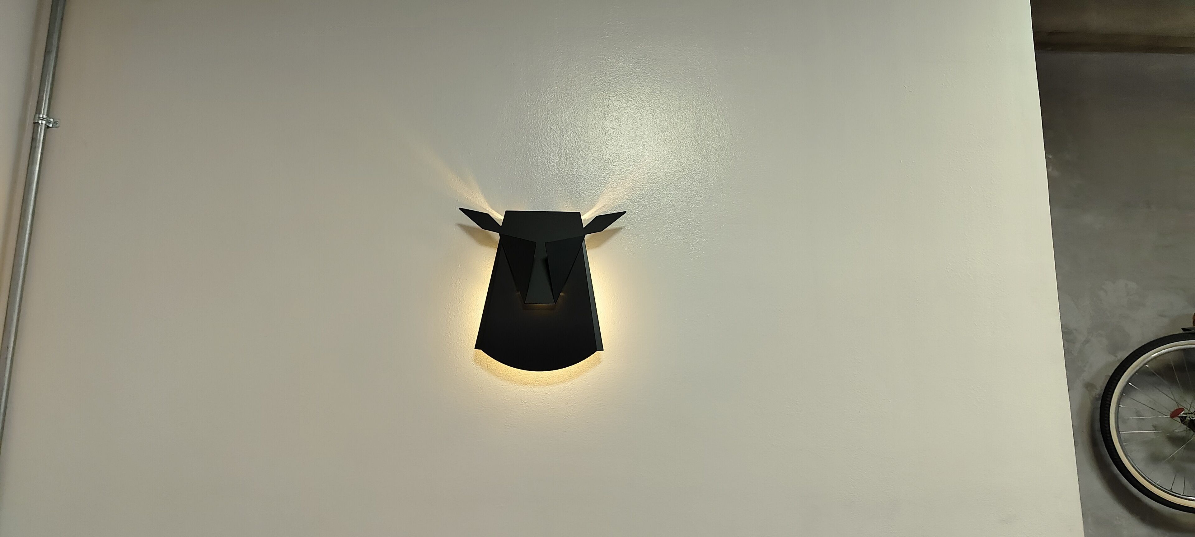 A wall-mounted light fixture shaped like a car with a circular light source.
