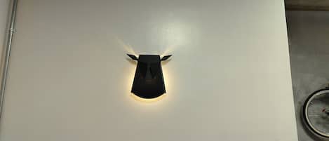 A wall-mounted light fixture shaped like a car with a circular light source.