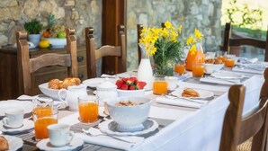 A breakfast table set with croissants, strawberries, orange juice, and a vase with yellow flowers. - Podere Il Chiesino 8 2 (Montecatini Val di Cecina)