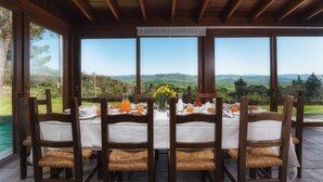 A table set for breakfast with a scenic view of rolling hills and a clear sky. - Podere Il Chiesino 8 2 (Montecatini Val di Cecina)