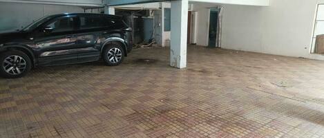 A parking garage with a car parked under a structure.