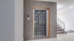 An elevator with a marble wall and a digital display showing the number 4. - Treebo Destination Inn (Hyderabad)