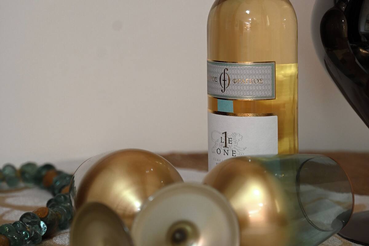 A bottle of wine, a glass, and a decorative item on a table.