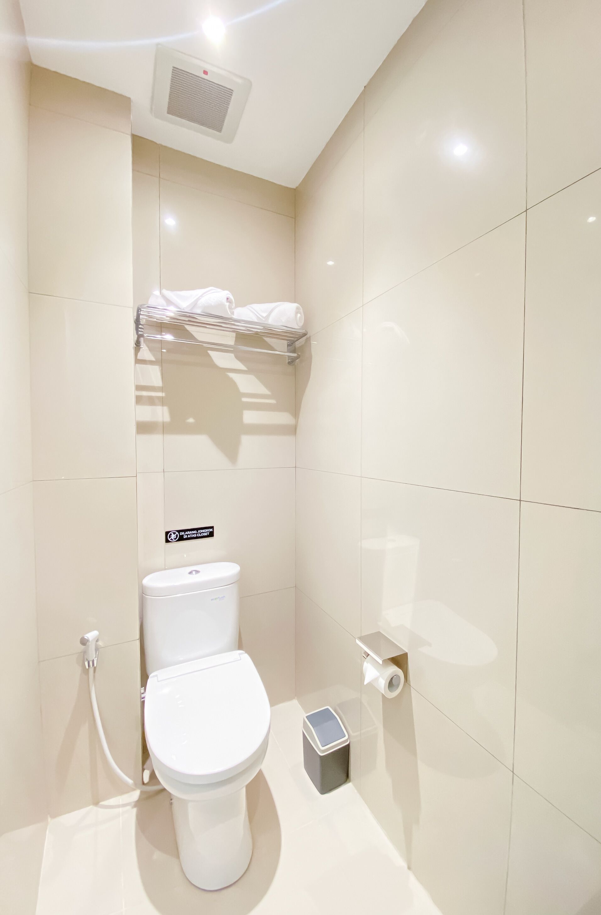 Un baño moderno con inodoro, secamanos y toallero.