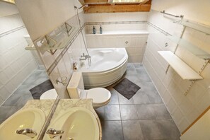 A bathroom with a bathtub, two sinks, and a toilet. - Charming duplex with a shared pool (Cournillens)
