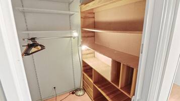 A walk-in closet with open shelving and a hanging rod.