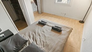 A bedroom with a bed, pillows, a bedside table, a window, and a floor lamp. - Charming duplex with a shared pool (Cournillens)