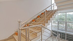 A staircase with granite steps, metal railings, and potted plants.