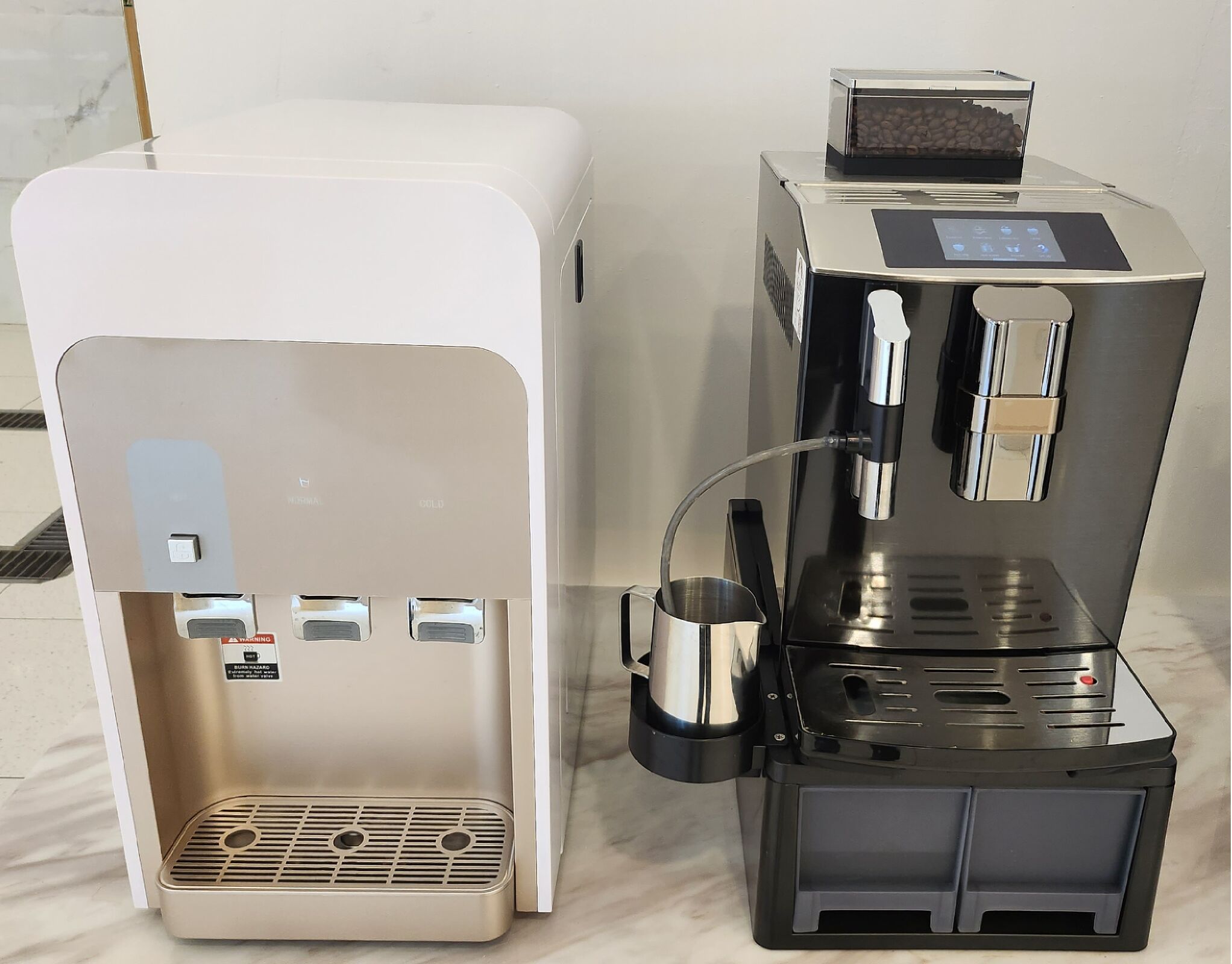 A coffee machine with a milk frother and a coffee dispenser.