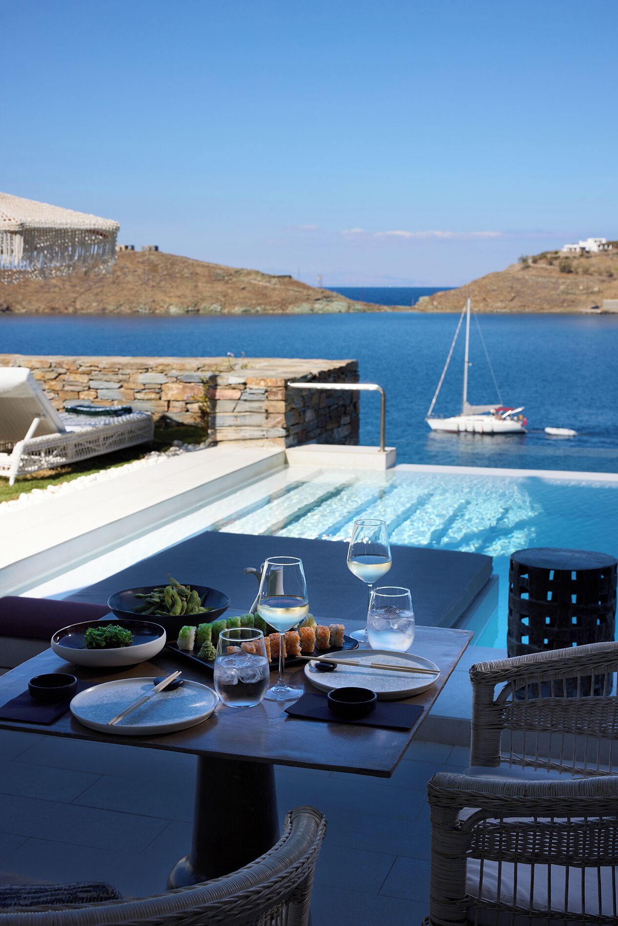 Una mesa de comedor con vista al mar y un barco.