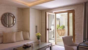 A modern living room with a sofa, a coffee table, a chair, and a large mirror on the wall.