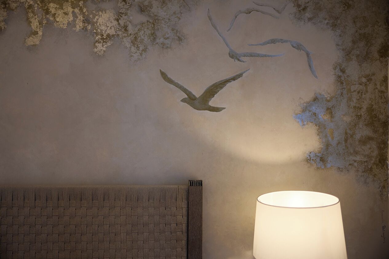 A wall with a textured surface and a lamp.