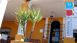 A building with a sign for 'EL PASANO HOSTAL RESTAURANTE'. - Hostal Restaurante Asador EL PAISANO (Utrera)