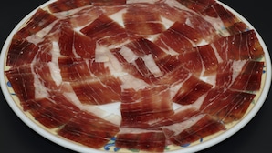 A round plate with neatly arranged slices of cured meat. - Hostal Restaurante Asador EL PAISANO (Utrera)