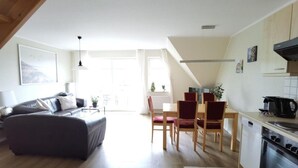 A modern apartment with a living room, dining area, and kitchen. - Schaake Hooksiel to feel good with 76sqm & balcony (Wangerland)