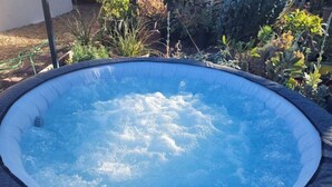 A hot tub surrounded by plants and a brick patio. - Urban Farm House +Hot Tub+Pool (Long Beach)