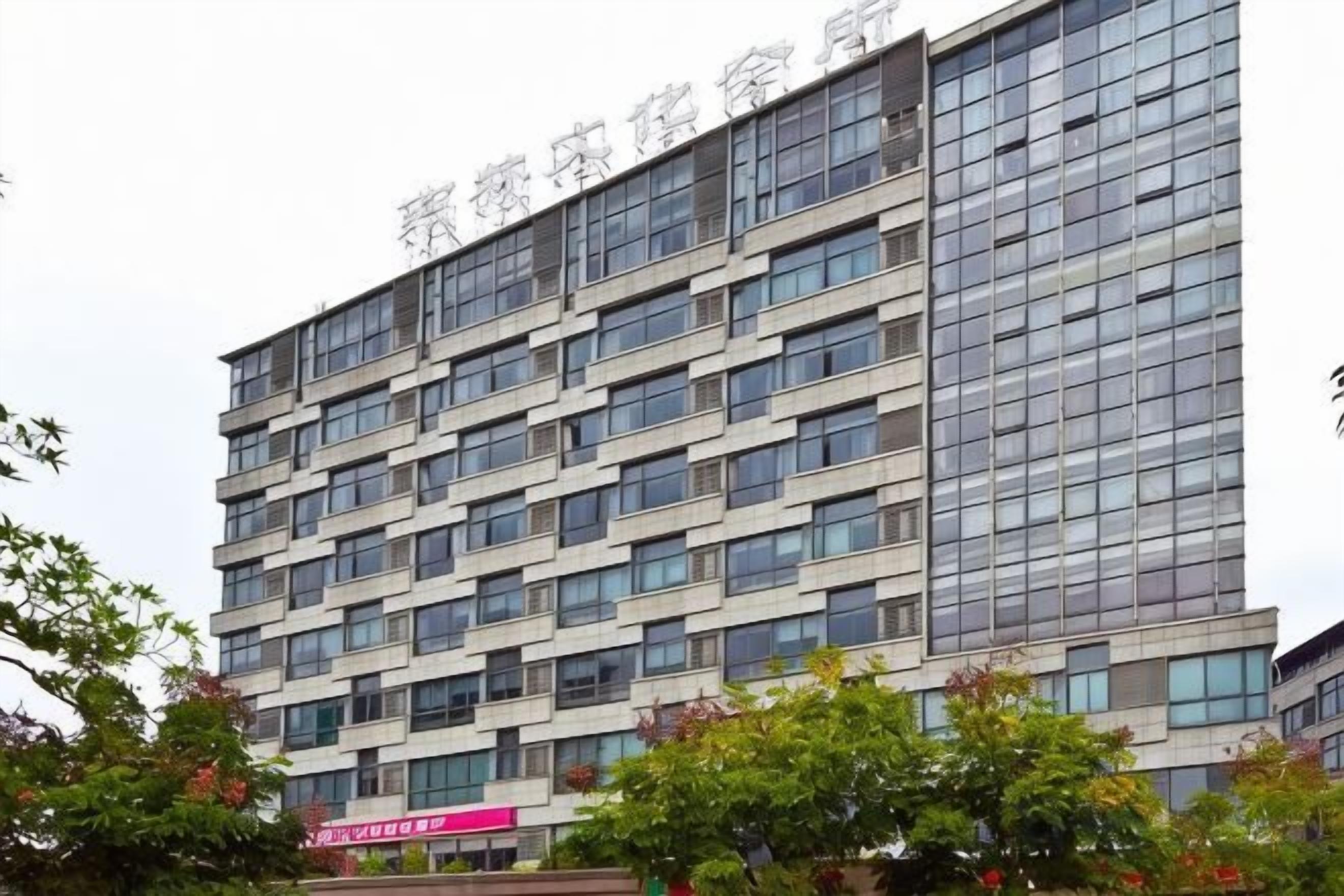 A multi-story building with a modern architectural design, featuring a series of windows and balconies.