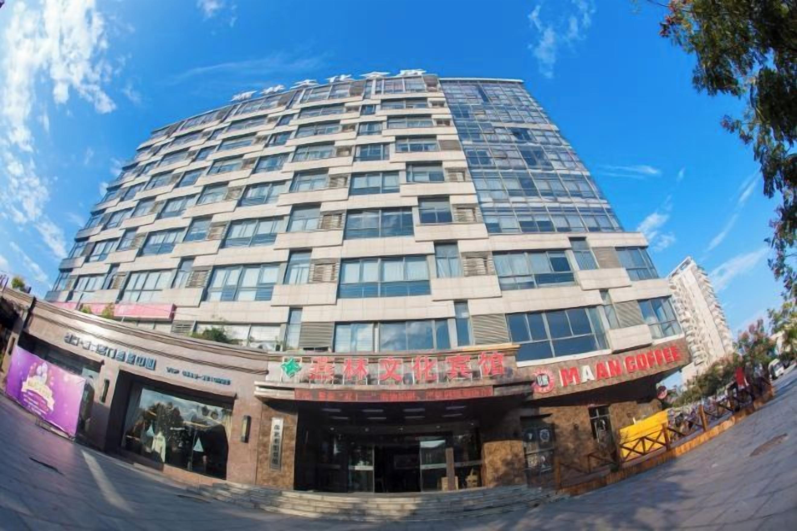 A multi-story building with a modern architectural design, featuring a prominent entrance with signage.