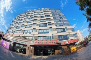A multi-story building with a modern architectural design, featuring a prominent entrance with signage.