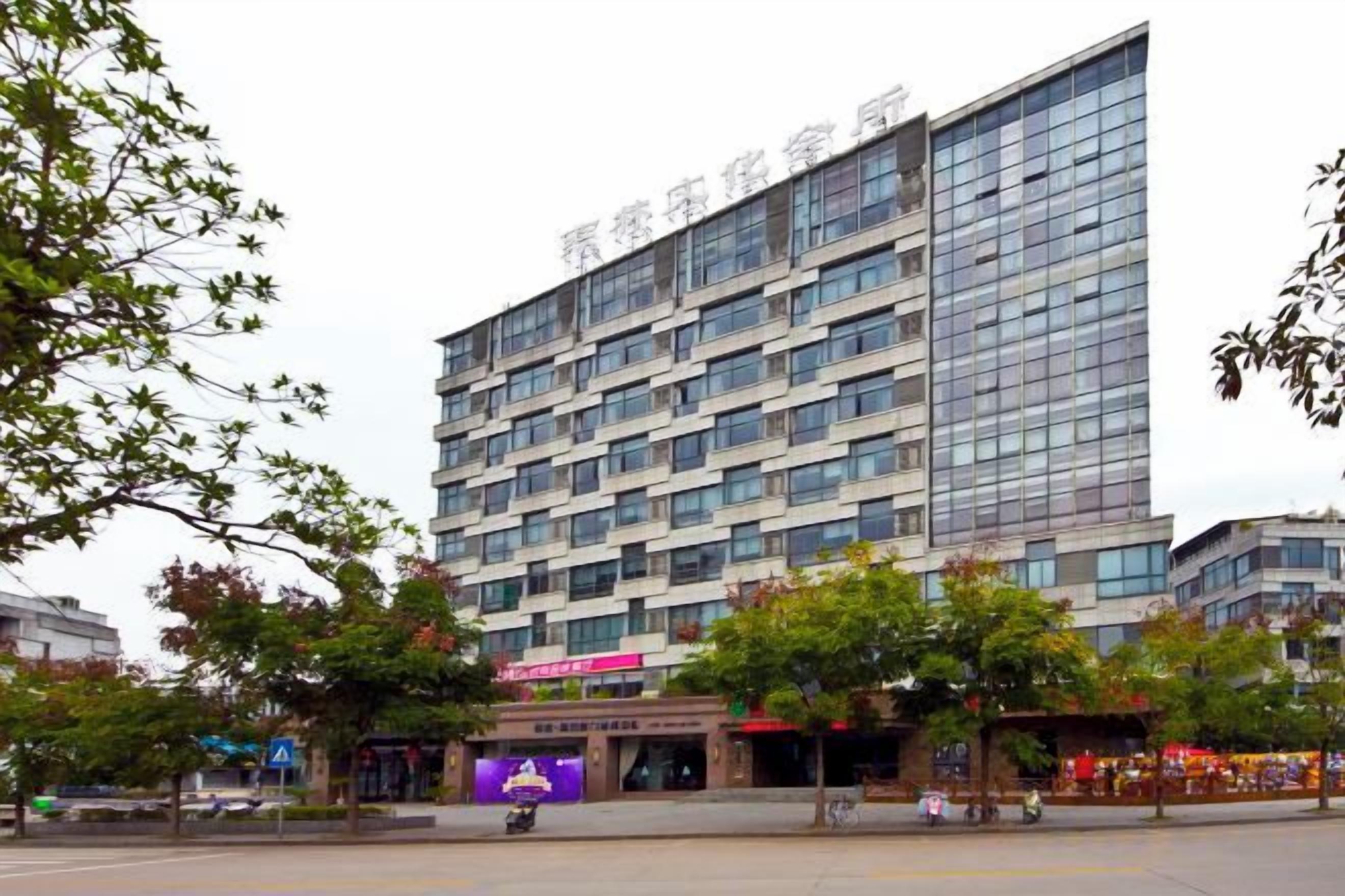 A multi-story hotel with a modern facade, large windows, and a flat roof.