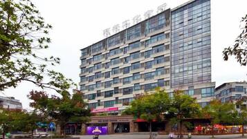 A multi-story hotel with a modern facade, large windows, and a flat roof.