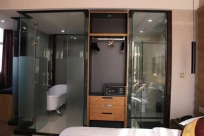 A modern bedroom with a glass-enclosed walk-in closet, a built-in bathtub, and a wooden dresser. - Yanlin Culture Hotel (Shaowu)