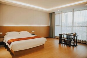 A hotel room with a bed, bedside tables, a desk with chairs, and a large window with curtains. - Yanlin Culture Hotel (Shaowu)