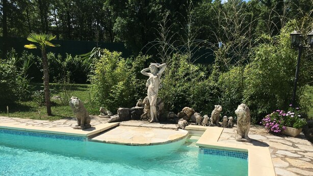 Une piscine avec des carreaux de pierre et un bord en pierre.