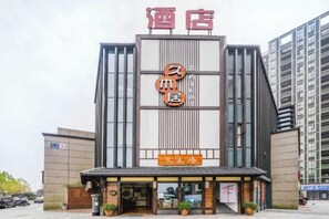 A hotel with a modern facade, a prominent sign with Chinese characters, and a traditional entrance. - Jiumuju Hotel (Anji)