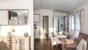 Une cuisine moderne avec un coin repas, un canapé et un miroir.