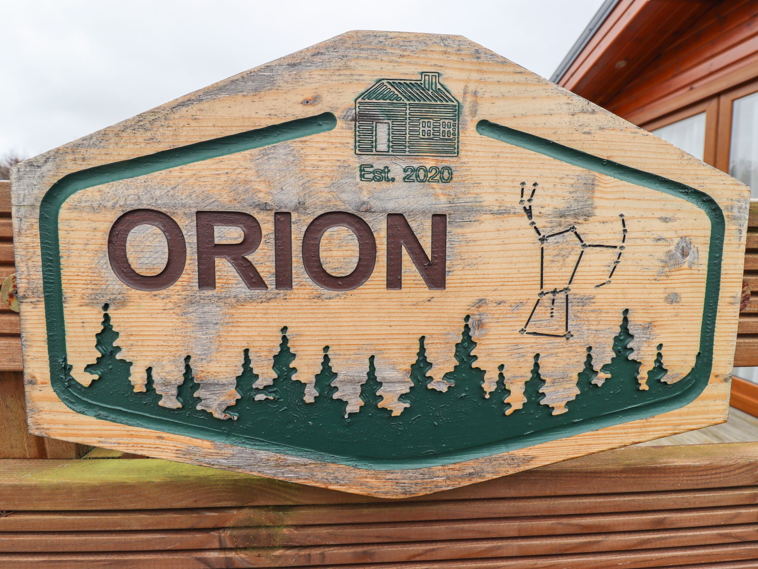 A wooden sign with the word "ORION" and a house icon with "Est. 2020" indicating the establishment year.