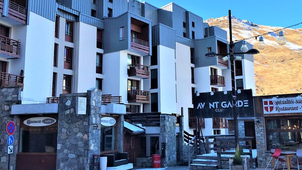 Ett hotell med flera våningar, balkonger, ett kafé och en restaurang.